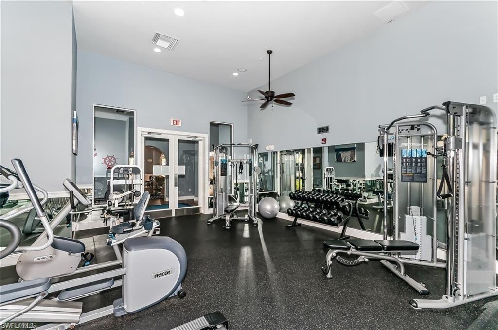 Gym with french doors, a high ceiling, a ceiling fan, and recessed lighting