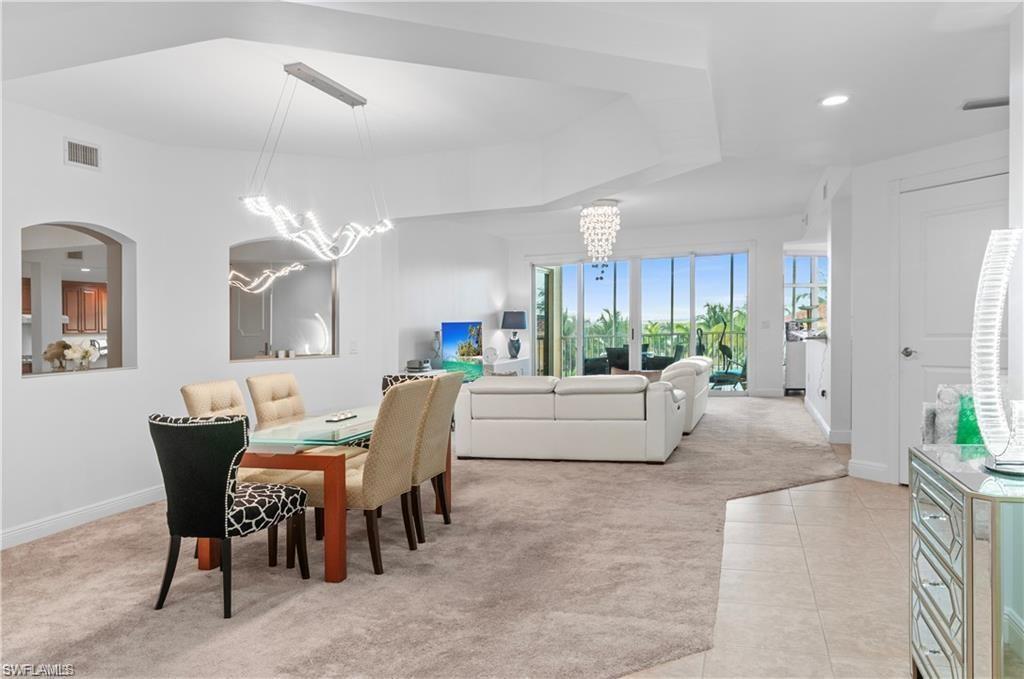 Dining area featuring light colored carpet, a chandelier, light tile patterned floors, and recessed lighting