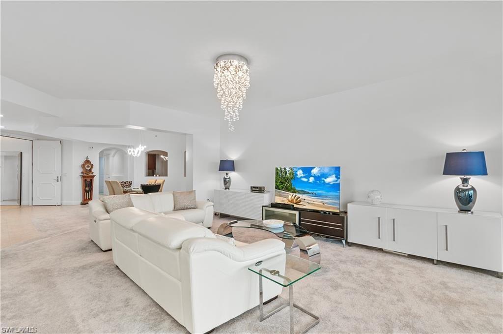 Living room featuring carpet and a chandelier