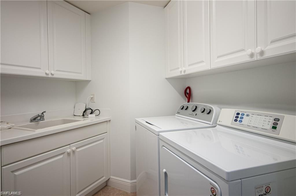 Washroom featuring washing machine and clothes dryer and cabinet space