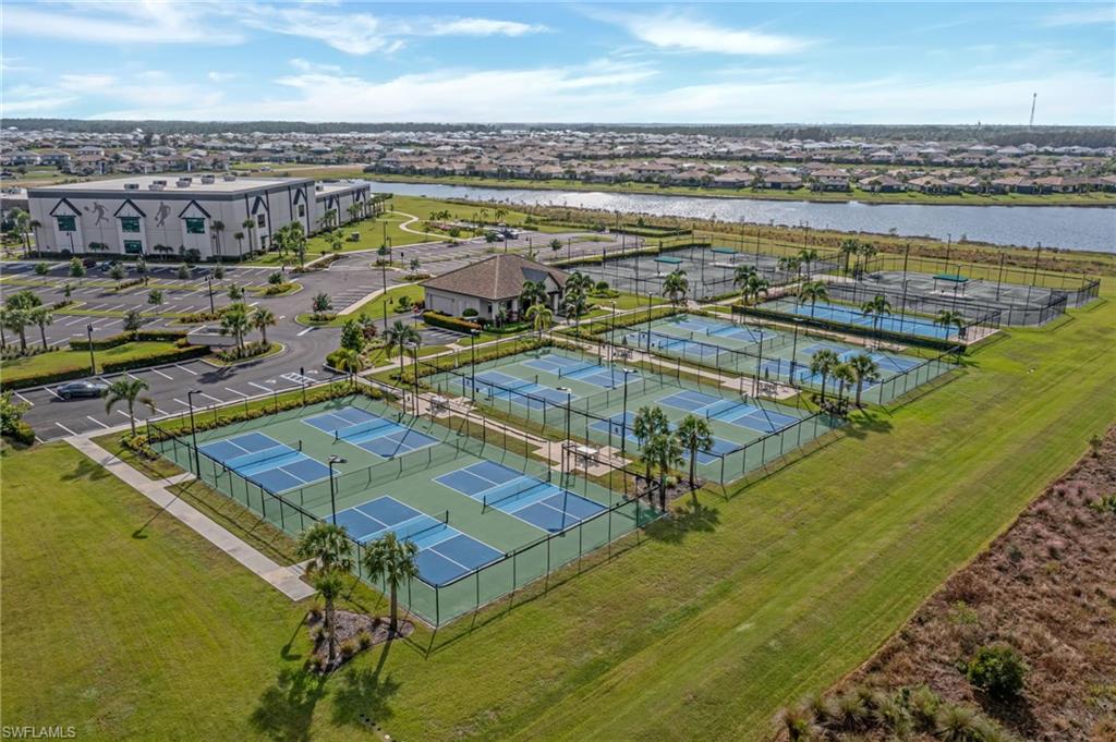 Multiple pickleball courts, several tennis courts, and a large recreational building