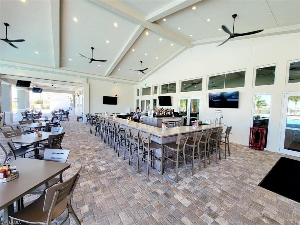 Dining space with ceiling fan, high vaulted ceiling, and plenty of natural light