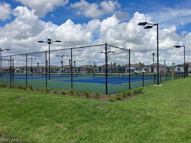 View of sport court with a yard