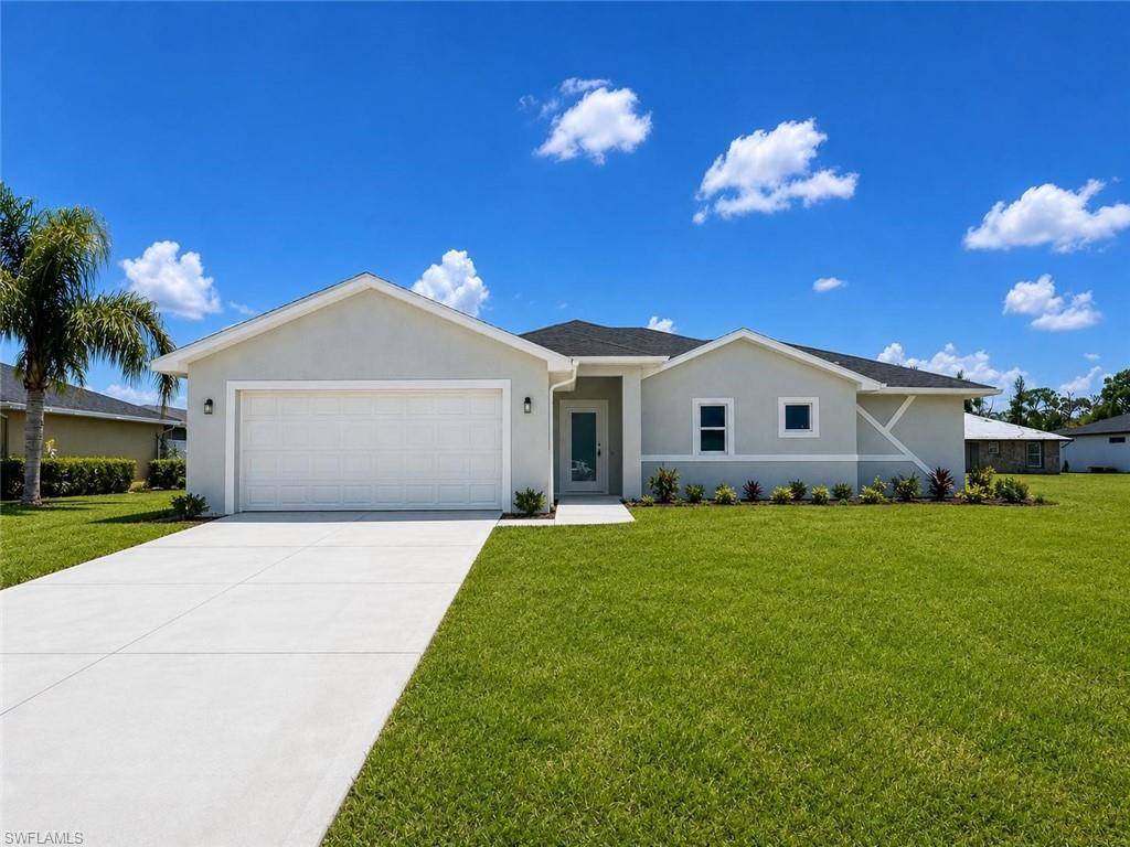 Contemporary stucco exterior with a two-car garage, concrete driveway, and front landscaping