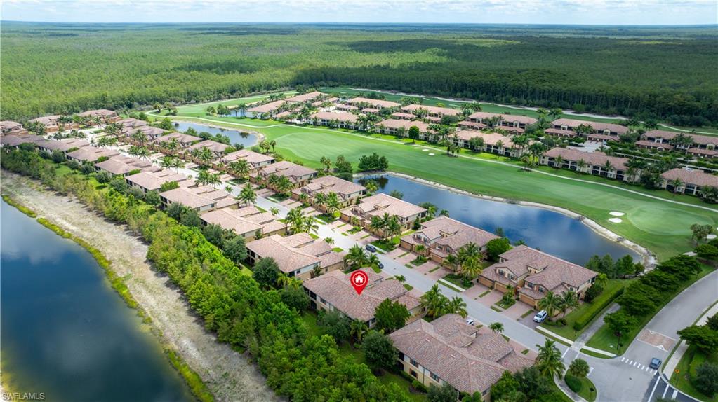 Community with tile-roofed residences, bordered by a large body of water