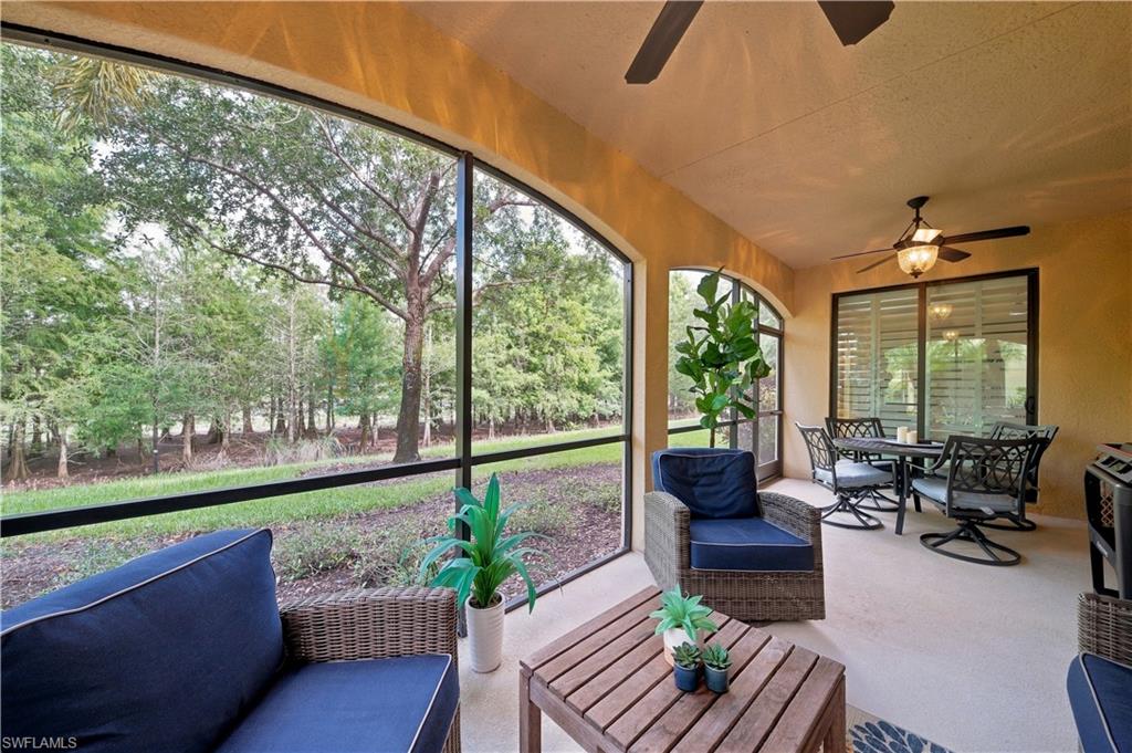 Screened patio featuring arched openings, a ceiling fan with integrated lighting, and louvered window treatments