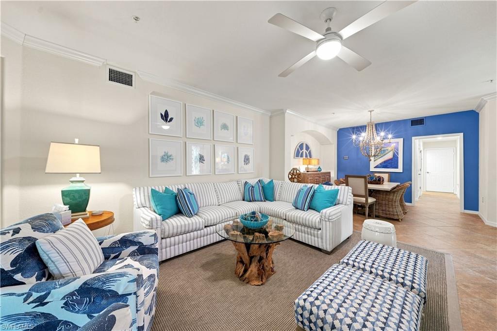 Open concept living and dining area with crown molding, ceiling fan, and wood-finish flooring