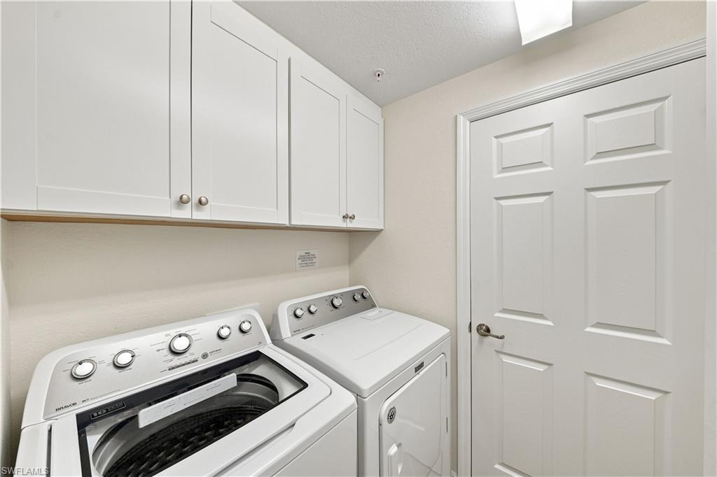 White shaker-style cabinetry, a contrasting wood shelf, and a paneled door with a brushed nickel handle