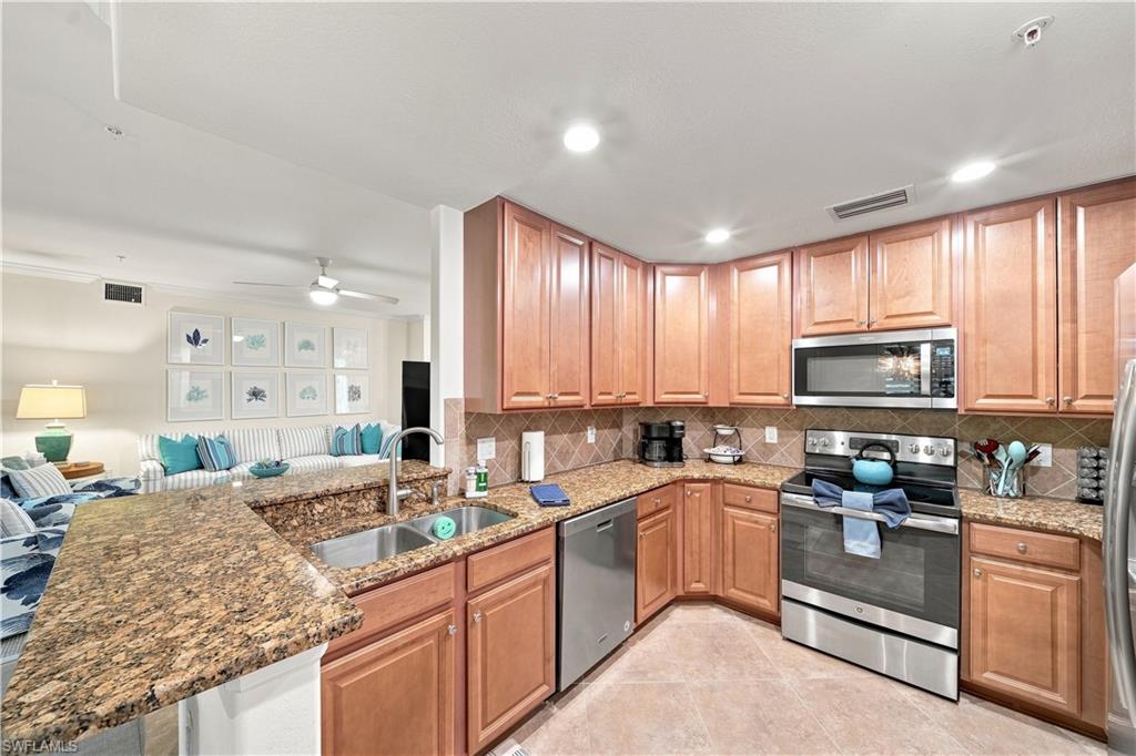 Kitchen featuring wood cabinetry, stainless steel appliances, granite countertops, and a tiled backsplash