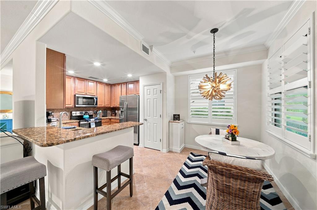 Kitchen featuring wood cabinetry, stainless steel appliances, and a granite-finish countertop