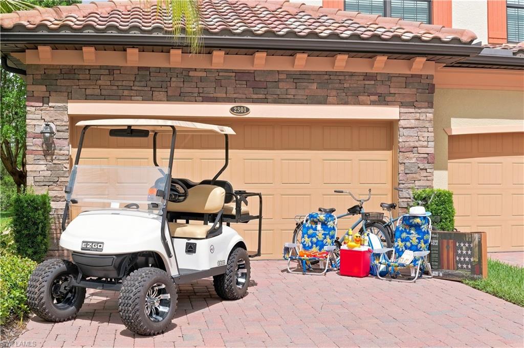 Paver driveway leading to a two-car garage with overhead doors
