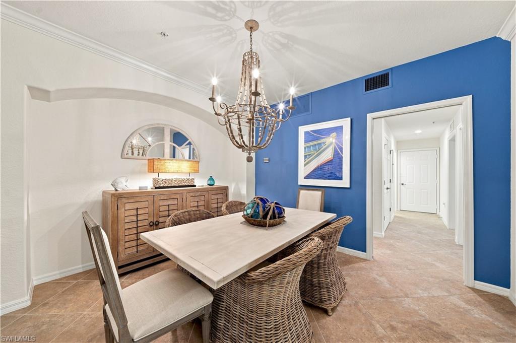Crown molding, arched doorway, recessed lighting, chandelier, and tile flooring