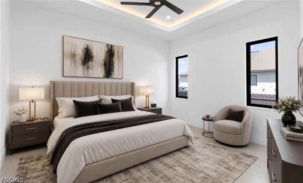 Tray ceiling with recessed lighting, ceiling fan, and two tall vertical windows with dark frames