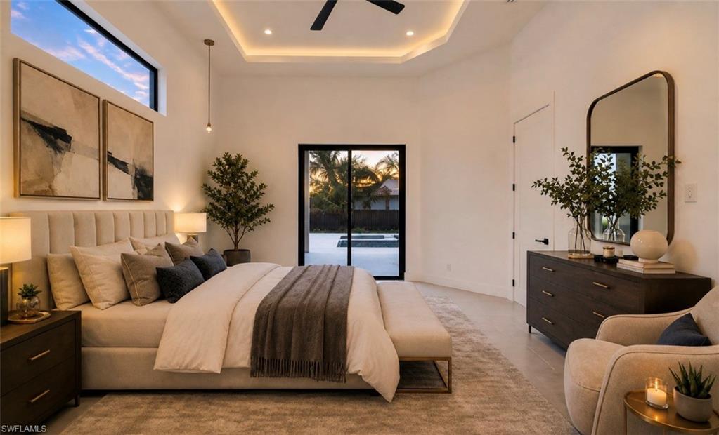 Recessed ceiling with perimeter lighting, transom window, and wood-finish flooring