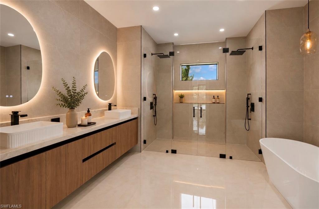 Dual vanity with integrated backlit mirrors, wood-finish cabinetry, and surface-mounted vessel sinks