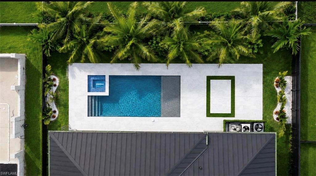 Rectangular pool with integrated spa and steps, surrounded by a white paver deck