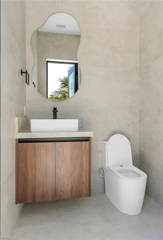 Floating wood-finish vanity with a stone countertop and vessel sink