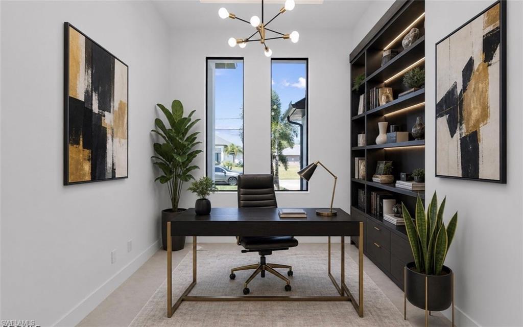 Built-in shelving with integrated lighting, two tall windows, light-toned flooring, and a modern chandelier