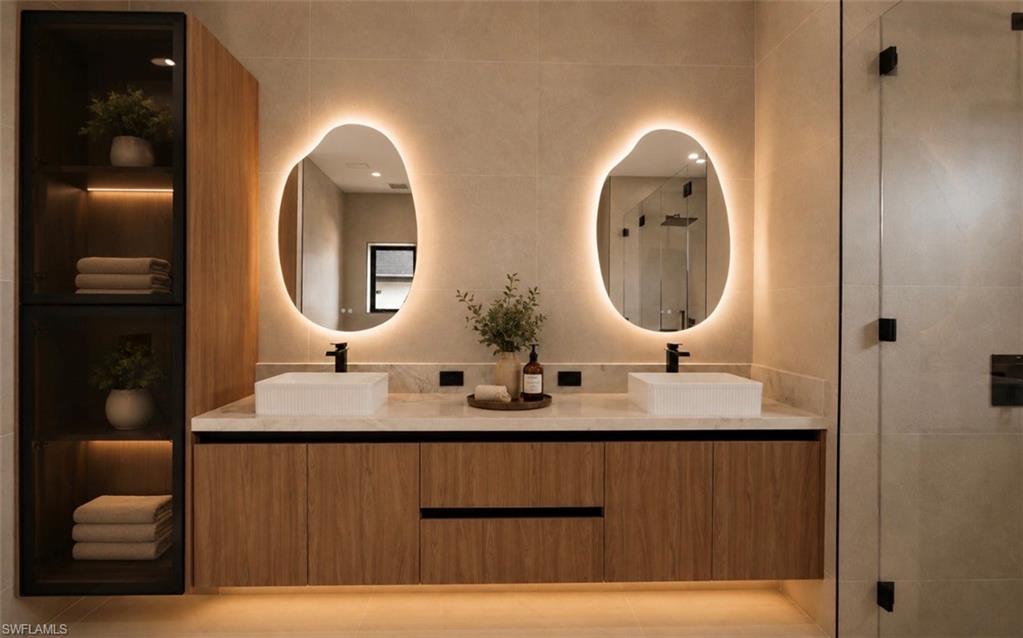 Dual vessel sinks set on a light-toned countertop, paired with wood-finish cabinetry
