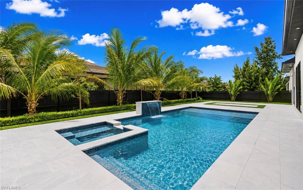 Rectangular swimming pool with integrated spa and waterfall feature