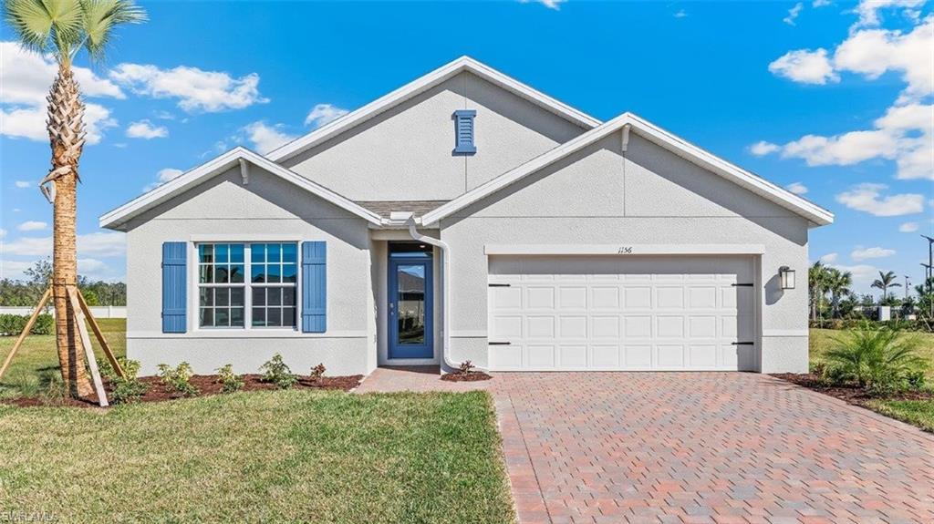 Contemporary single-story residence featuring a light gray stucco exterior with blue shutters and a coordinating blue entry door