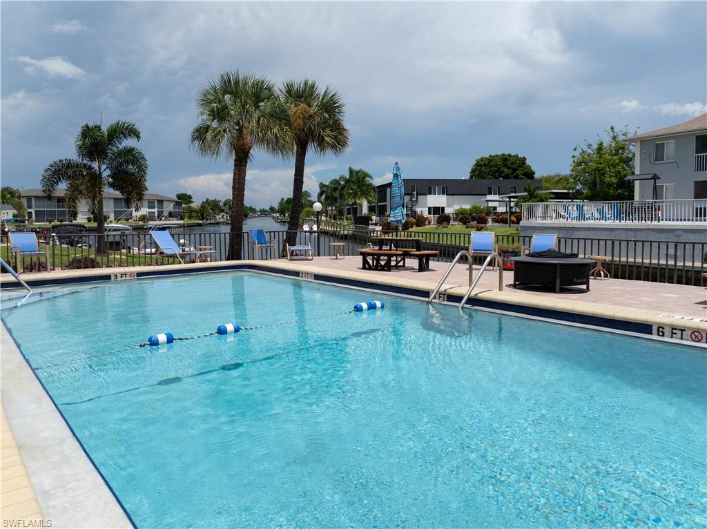 Rectangular swimming pool with integrated steps and handrails, surrounded by a paver deck