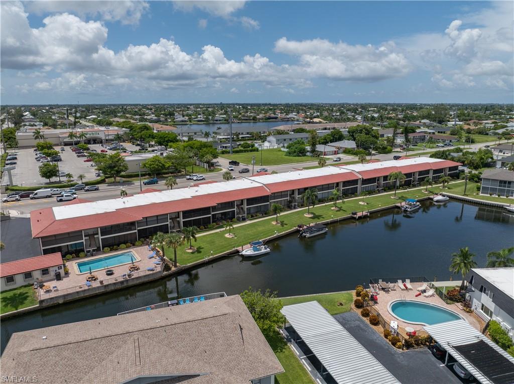 Waterfront property with multiple boat slips, a swimming pool, and covered parking