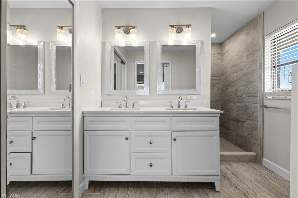 Dual vanities with white cabinetry, polished chrome faucets, and quartz countertops