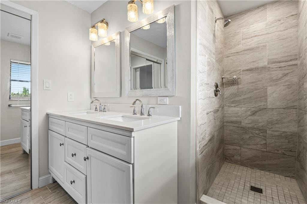 Dual vanity with white cabinetry, polished chrome fixtures, and integrated sinks