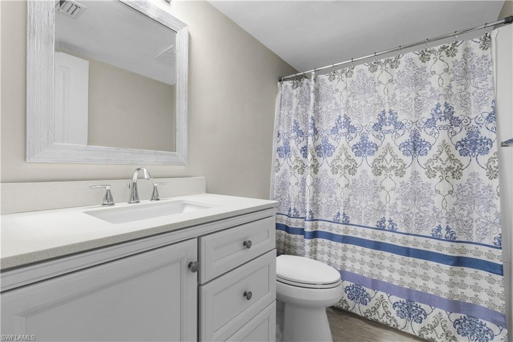 White vanity with integrated sink, chrome faucet, and framed wall mirror