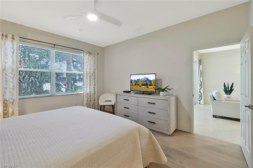 Bedroom with light wood-style floors, visible vents, and ceiling fan
