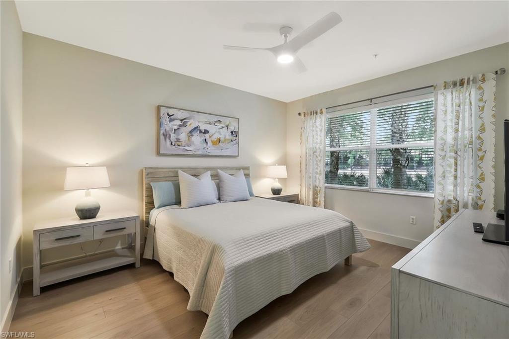 Bedroom with light wood-style floors, ceiling fan, and baseboards