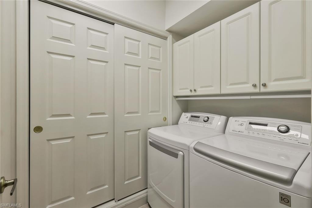 Washroom featuring independent washer and dryer and cabinet space