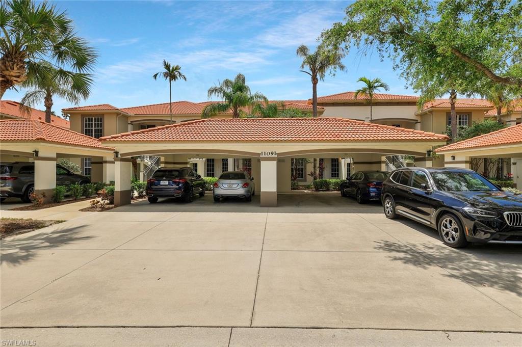 View of front of property with a tiled roof, concrete driveway, and stucco siding
