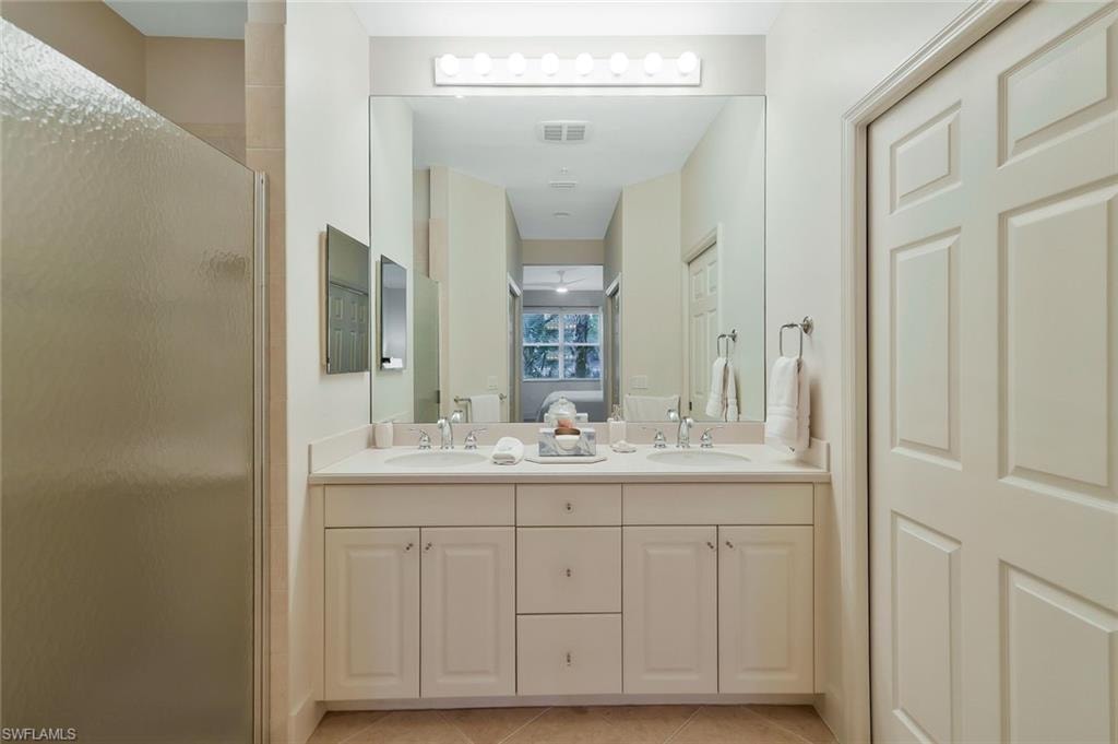 Ensuite bathroom with a shower stall, ensuite bath, visible vents, a sink, and tile patterned floors