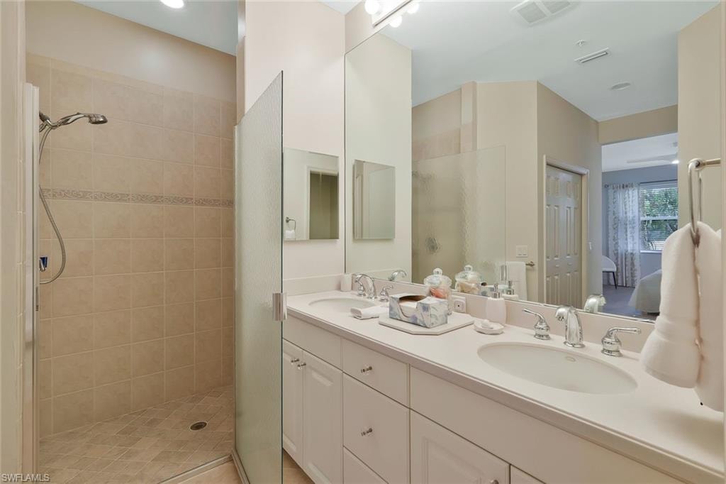 Bathroom featuring a sink, visible vents, and a tile shower
