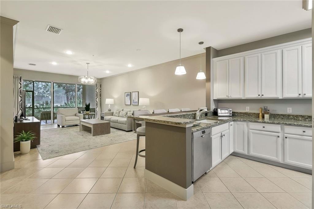 Kitchen featuring stainless steel dishwasher, open floor plan, visible vents, and light tile patterned floors