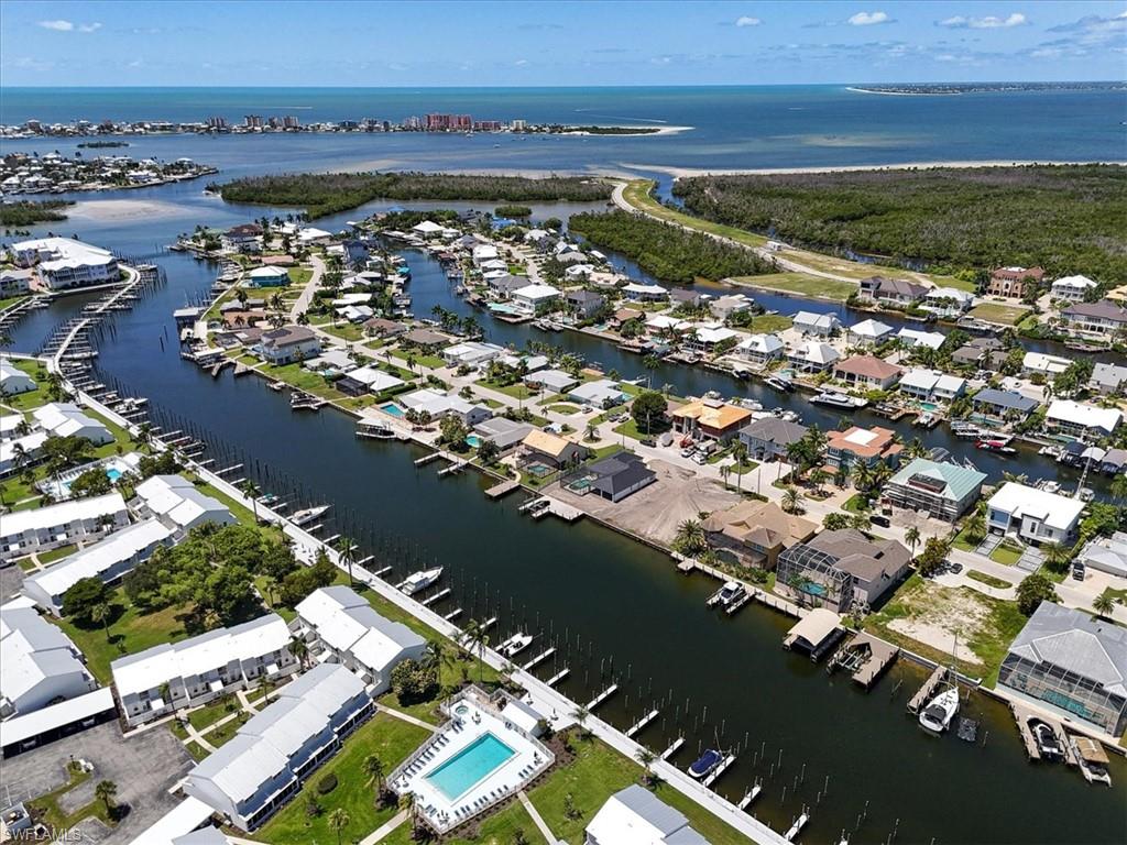 Waterfront canal community with direct Gulf access, individual boat docks, multiple residential structures, and an outdoor swimming pool