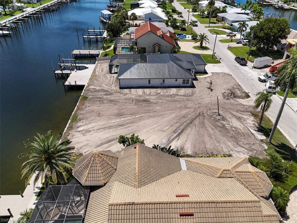 Waterfront lot with canal access, featuring boat docks and a cleared building site
