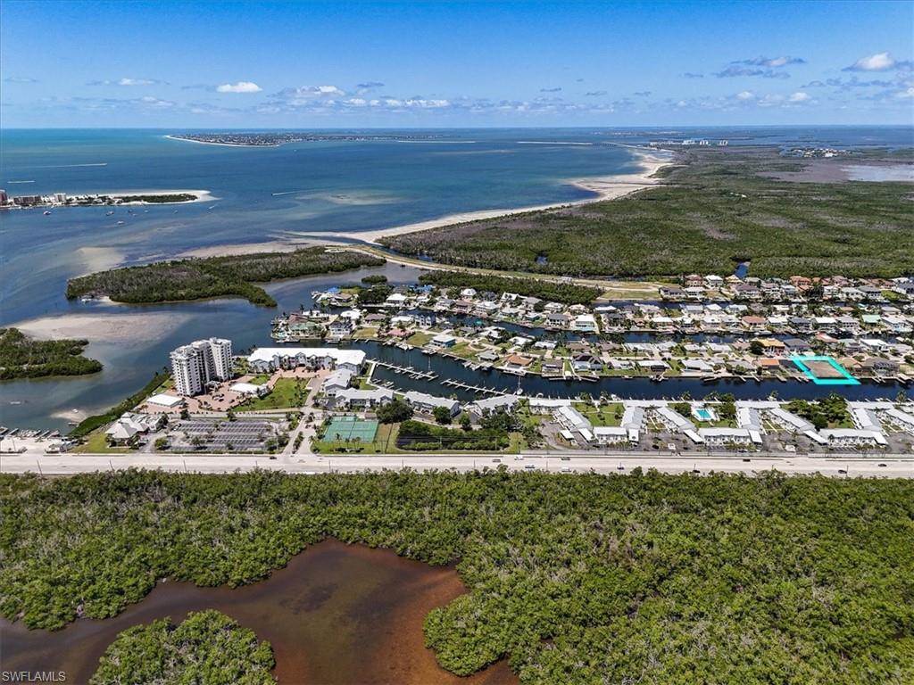 Waterfront canal access, expansive water body, residential neighborhood, adjacent green space, clear blue skies