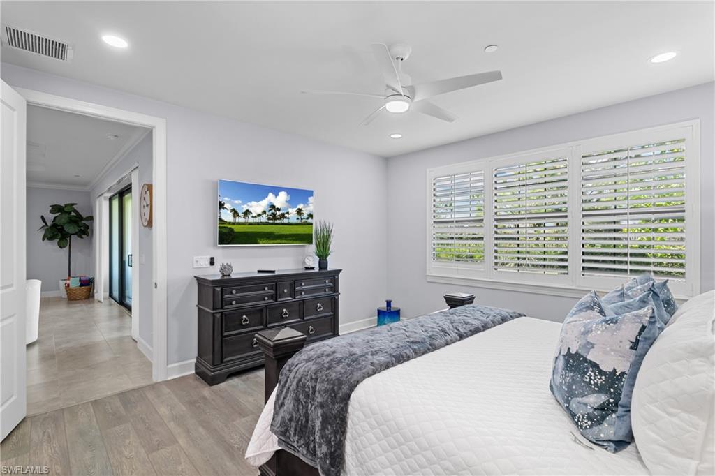 Light wood-finish flooring, recessed lighting, and a ceiling fan with integrated light