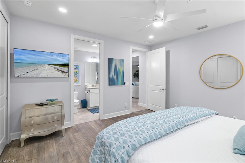 Recessed lighting, wood-finish flooring, ceiling fan, solid core doors, and a vanity with a rectangular sink