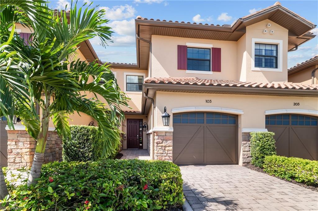 Mediterranean-style architecture with a stucco exterior, tiled roof, and stone-clad accents