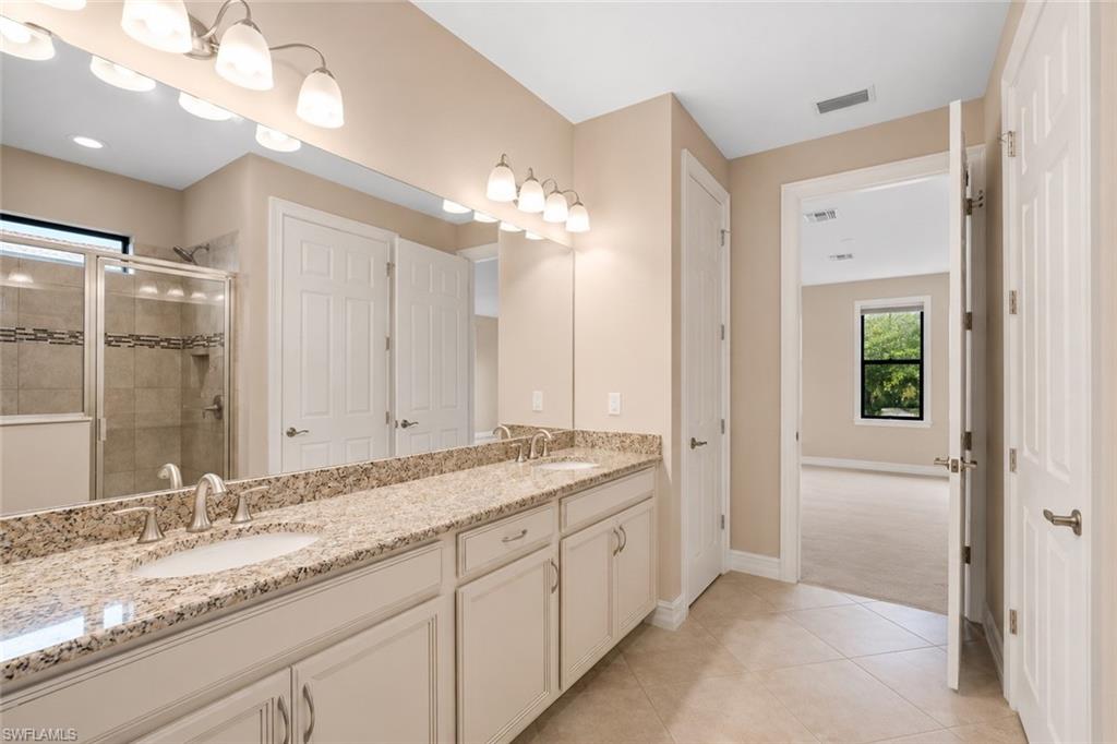 Double vanity with integrated sinks, speckled countertop, and brushed nickel fixtures