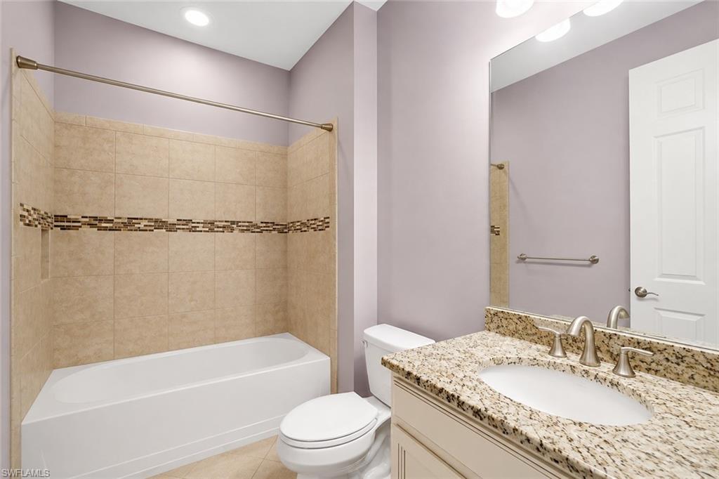 Bathroom featuring a white vanity with a granite countertop, undermount sink, and brushed nickel fixtures