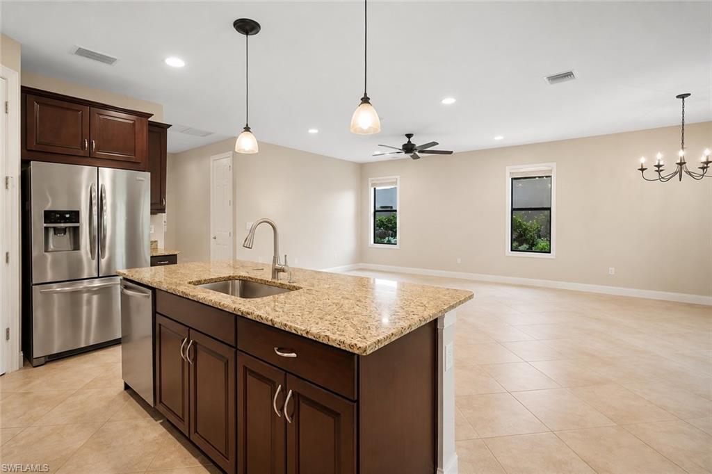 Kitchen island with a stainless steel sink and faucet, integrated dishwasher, and granite countertop