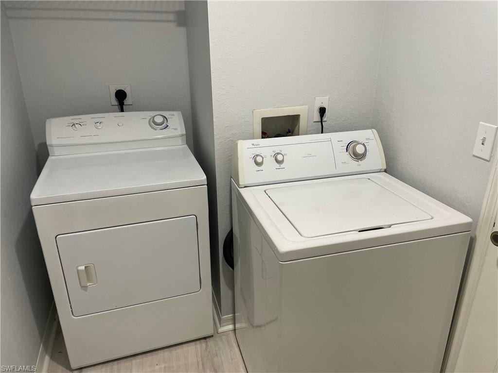 Laundry area featuring light wood-type flooring and washing machine and dryer