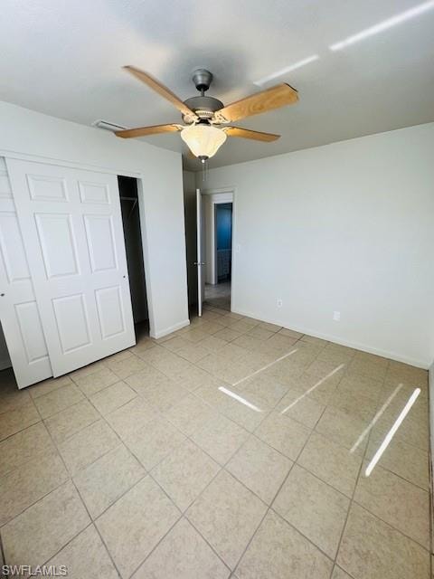 Neutral wall color, tiled flooring, ceiling fan with light fixture, and bifold closet doors