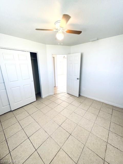 Neutral-toned tile flooring, white walls, and a ceiling fan with integrated lighting