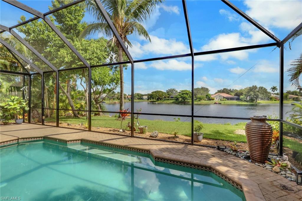 Screened enclosure featuring a swimming pool with steps, a paver deck, and a water feature